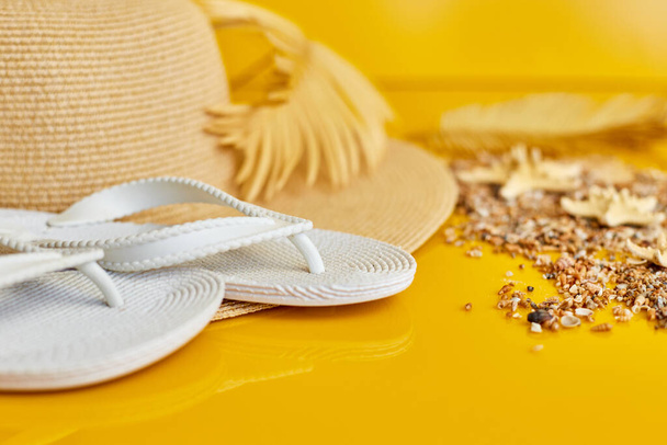 Accesorio de playa chancla blanca y sombrero de playa, concha marina, palma sobre fondo amarillo, vacaciones de verano y el concepto de vacaciones, Vista superior  - Foto, Imagen