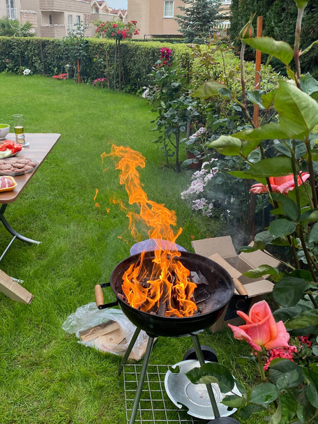 Fogo de churrasco no jardim de casa com grama. Pronto para cozinhar. - Foto, Imagem