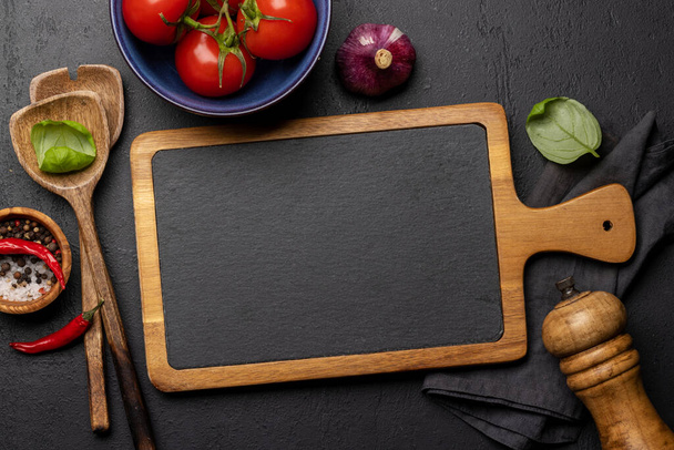 Top-down view of a kitchen table with ingredients, utensils, and chalkboard with copy space, perfect for creating a mockup for recipes or menus - Foto, Imagem