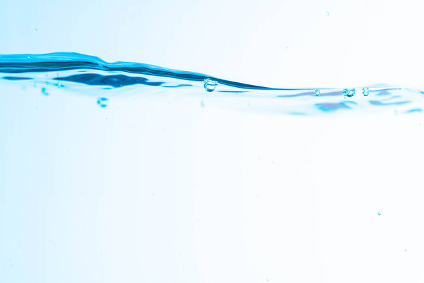 Фон изображения движущейся воды в волнах изолированы на белом фоне, чистая вода, пузырьки воды, макрос - Фото, изображение
