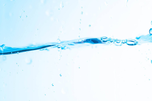 Achtergrond beeld van bewegend water in golven geïsoleerd op witte achtergrond, helder water, waterbellen, macro - Foto, afbeelding