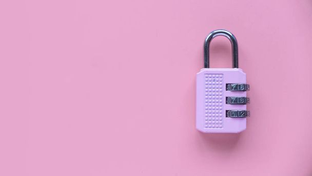 Safety and protection concept. Pink padlock isolated on a pink background with copy space. - Photo, Image