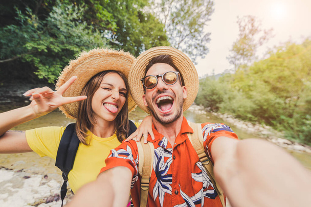 Bláznivý pár v lásce cestování venku a přičemž selfie s mobilním telefonem - Šťastný mladý muž a žena dělat autoportrét s chytrým telefonem - Fotografie, Obrázek