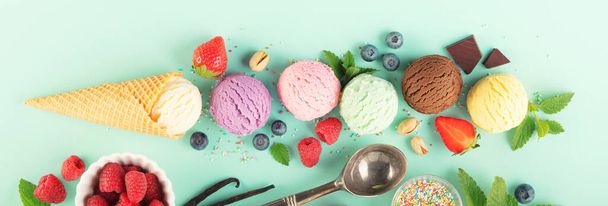 Flying ice cream balls and ingredients on pastel light blue background. Summer minimal concept - Zdjęcie, obraz