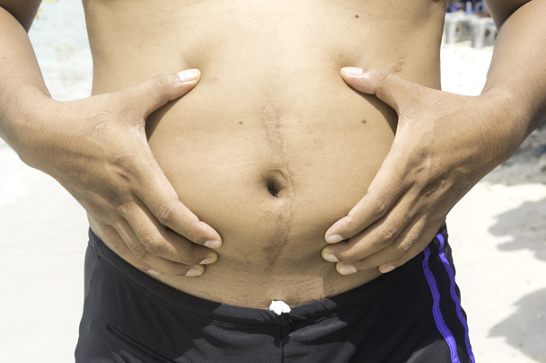 Mann greift sich sein Fett am Bauch - Foto, Bild
