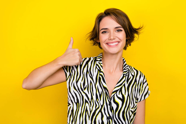 Portrait of cute lady worker raise thumb up approving good quality wear print summer blouse isolated yellow color background. - Photo, Image