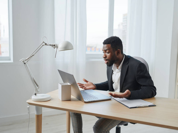 man taulukko verkossa koulutus kannettava tietokone liike soittaa mies istuu moderni työpaikka sisätiloissa amerikkalainen musta afrikkalainen tietokone cyberspace freelancer afrikkalainen amerikkalainen opiskelija - Valokuva, kuva