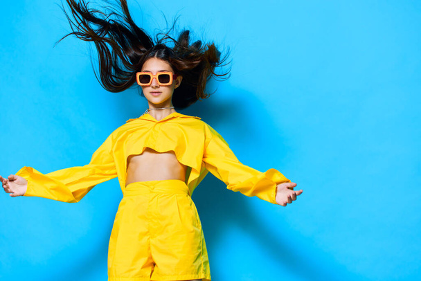 okulary przeciwsłoneczne kobieta odizolowany modny taniec młody radosny moda żółty atrakcyjny brunetka styl życia glamour radość fryzura dziewczyna lato twórczy gest osoba piękna - Zdjęcie, obraz