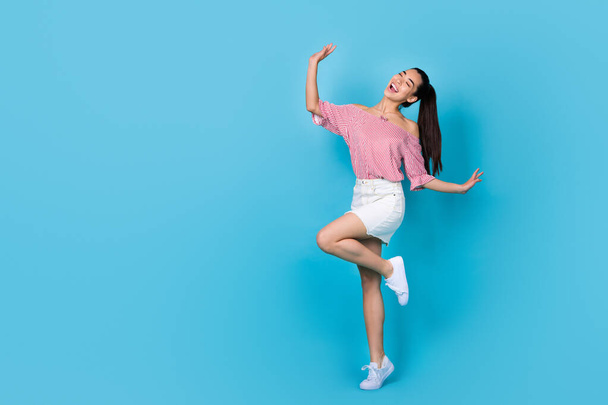 Full length photo of sweet carefree lady wear off shoulders red blouse having fun dancing empty space isolated blue color background. - Φωτογραφία, εικόνα