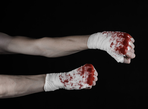 Shook his bloody hand in a bandage, bloody bandage, fight club, street fight, violence, bloody theme, isolated, bloody fists, boxer, tied his hands with a bandage, black background - Foto, imagen