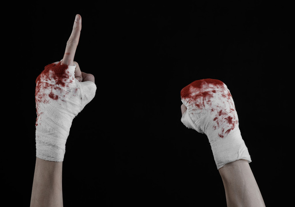 Shook his bloody hand in a bandage, bloody bandage, fight club, street fight, violence, bloody theme, isolated, bloody fists, boxer, tied his hands with a bandage, black background - Valokuva, kuva