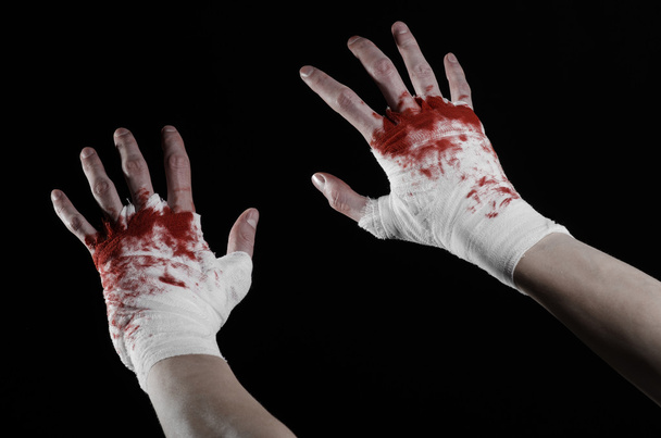 Shook his bloody hand in a bandage, bloody bandage, fight club, street fight, violence, bloody theme, isolated, bloody fists, boxer, tied his hands with a bandage, black background - 写真・画像