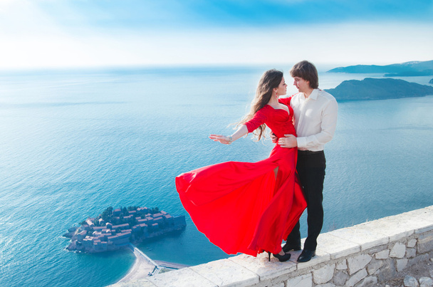 Romantic young couple in love. Fashion girl model in blowing red - Photo, Image