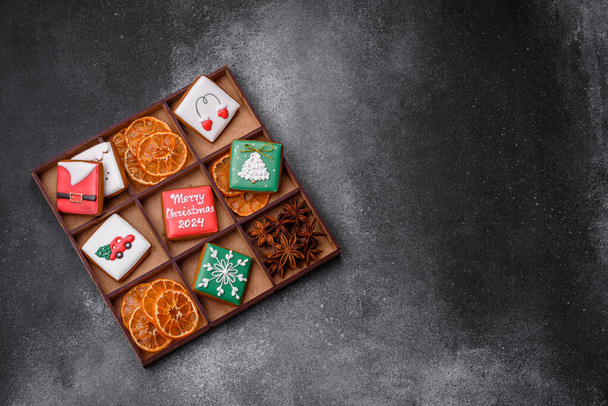 Όμορφα χρωματιστά χριστουγεννιάτικα μπισκότα με μελόψωμο για το σχεδιασμό και τη διακόσμηση του εορταστικού τραπεζιού σε φόντο από μπετόν με υφή - Φωτογραφία, εικόνα