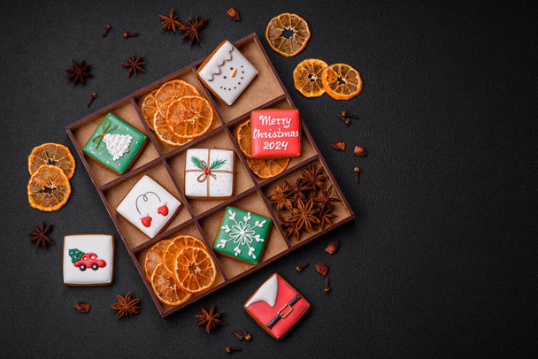 Gyönyörű színes karácsonyi mézeskalács cookie-k a tervezés és dekoráció az ünnepi asztal egy texturált beton háttér - Fotó, kép