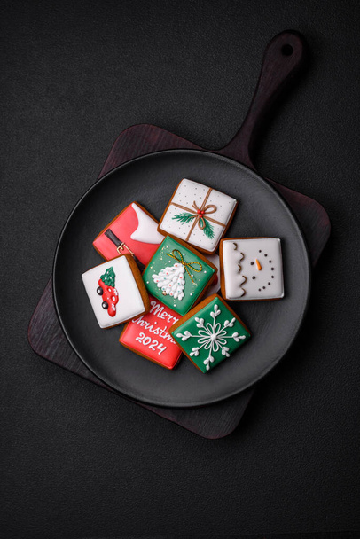 Beautiful colored Christmas gingerbread cookies for the design and decoration of the festive table on a textured concrete background - Foto, Imagen