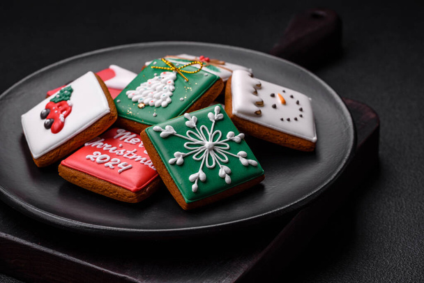 Beautiful colored Christmas gingerbread cookies for the design and decoration of the festive table on a textured concrete background - Φωτογραφία, εικόνα