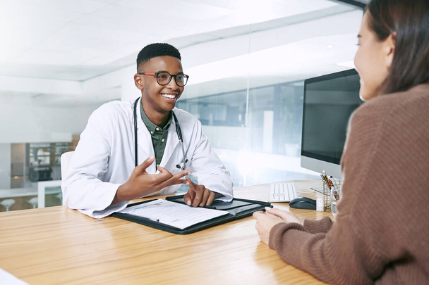 Please remember these two things. a handsome doctor sitting with his patient and explaining her diagnosis during a consultation in the clinic - Foto, afbeelding