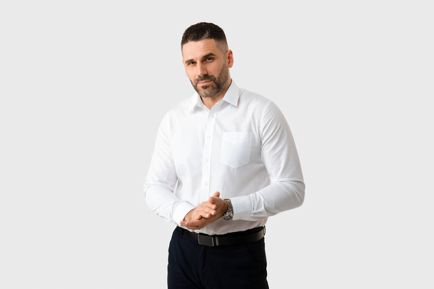 Portrait of serious handsome middle aged businessman posing looking at camera over light grey studio background. Shot of confident male in shirt. Self confidence concept - Valokuva, kuva