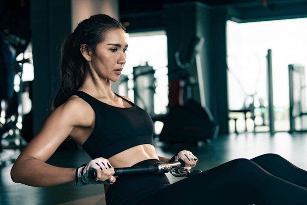 Mujer deportiva haciendo ejercicio en la estación múltiple en el gimnasio para los músculos del brazo y los hombros. Ejercicio de fitness en gimnasio. - Foto, imagen