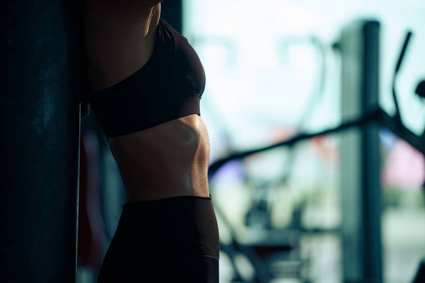 Спортивная женщина, демонстрирующая свое хорошо подготовленное тело с сильными животами. - Фото, изображение