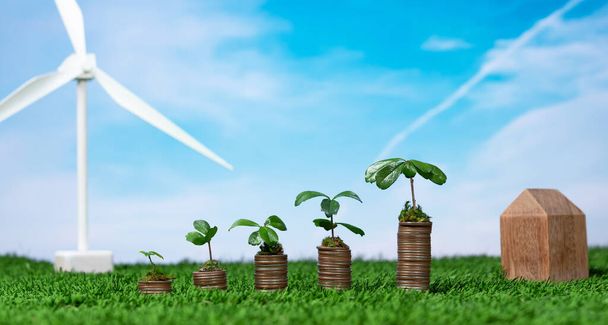 Ekoyritysinvestoinnit tai ympäristönsuojelu tukevat konseptia, kolikkopinoa, jossa kasvava taimi päälle ja tuuliturbiini. Kestävä talouskasvu puhtaan ja uusiutuvan energian avulla. Muuta - Valokuva, kuva