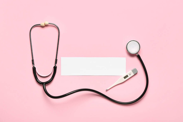 Composition with blank sheet of paper, stethoscope and thermometer on color background. Melanoma concept - Photo, Image