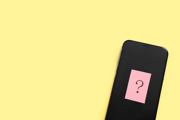 Mobile phone with question mark on yellow background - Photo, Image