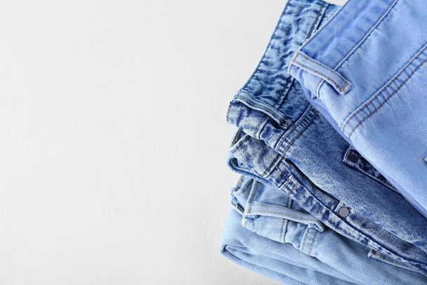 Folded jeans on white background, closeup - Фото, изображение
