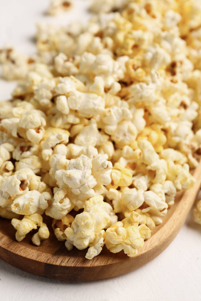 Wooden board with crispy popcorn on light background - Photo, Image