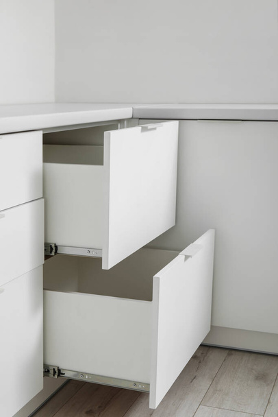 Open white drawers in light kitchen - Foto, Bild