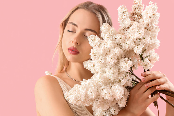 fiatal nő orgona virágok rózsaszín háttér, közelkép - Fotó, kép