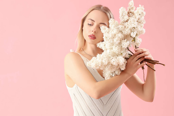 fiatal nő orgona virágok rózsaszín háttér - Fotó, kép