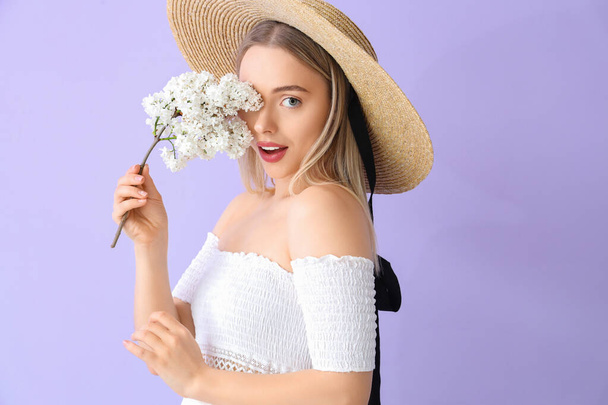 Young woman with lilac flowers on color background - Photo, Image
