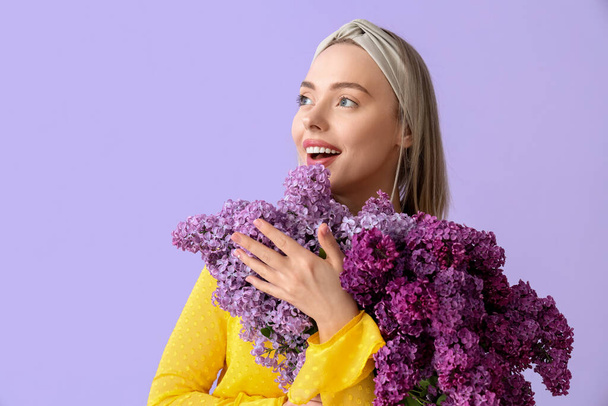 背景色に薄紫色の花を持つ若い女性,クローズアップ - 写真・画像