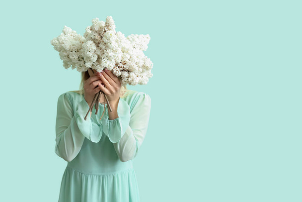 fiatal nő orgona virágok menta háttér - Fotó, kép