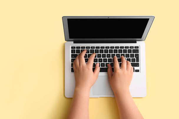 Female hands with modern laptop on beige background - 写真・画像