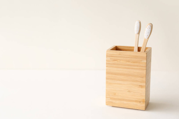 Bamboo tooth brushes in holder on light background - Foto, Bild