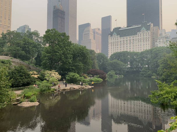 Central Park-NYC Under Wildfire Smoke uit Canada. 7 juni 2023, New York, VS: Een wolk rook bereikt de VS vanuit Canada, waar honderden bosbranden het land treffen. De VS waarschuwt kwetsbare bevolkingsgroepen om binnen te blijven.. - Foto, afbeelding