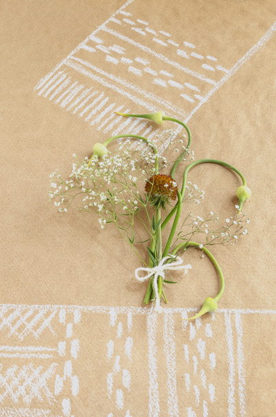Still life with garlic buds and bouquet flowers on paper drawing with towel - Photo, Image