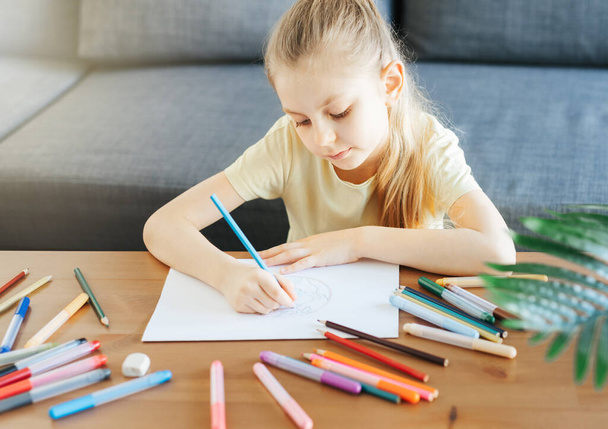 Child girl drawing with colorful pencils at home. Ecology concept, painting earth.  - Photo, image
