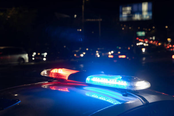 Police car with flashing lights on at nigh - Φωτογραφία, εικόνα