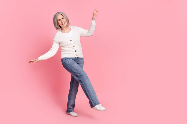 Full body photo of excited positive aged person dancing clubbing empty space isolated on pink color background. - Foto, imagen