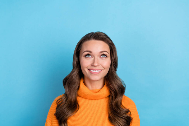Photo of cheerful dreamy woman dressed orange sweater looking up empty space isolated blue color background. - Fotografie, Obrázek