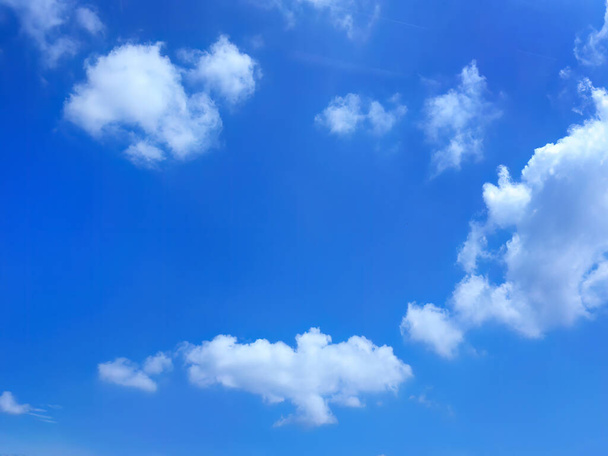 Low angle view of beautiful bright blue sky and white fluffy clouds, cloudscape, natural shape, bright day in summer - Photo, Image