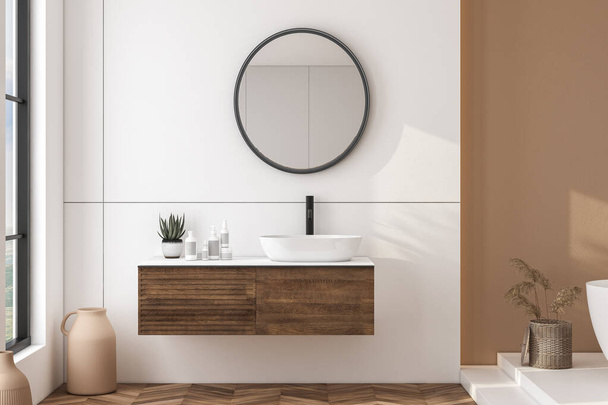 Modern bathroom interior with beige walls, white sink with oval mirror, bathtub and parquet floor. Minimalist bright bathroom with modern furniture. front view.3D rendering - Photo, Image