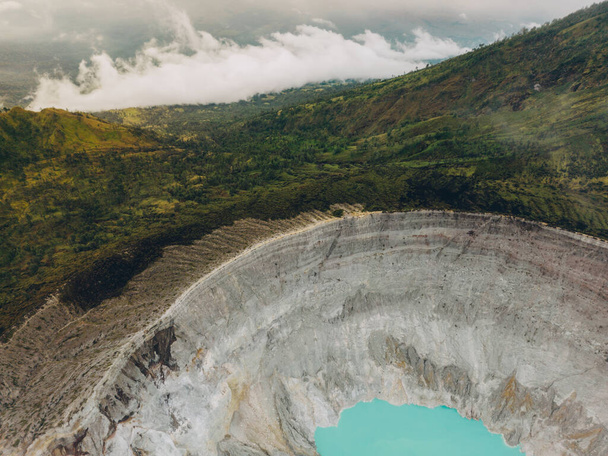 Верхній вигляд бірюзового сірчаного озера, оточеного гірською скелею в вулкані Кава-Іджен у Східній Яві (Індонезія).. - Фото, зображення
