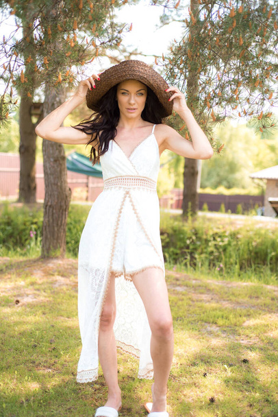 красива жінка в білій сукні і капелюсі в літній день в саду
  - Фото, зображення