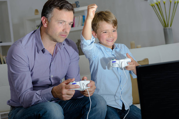 Child beating adult on computer game - Фото, изображение