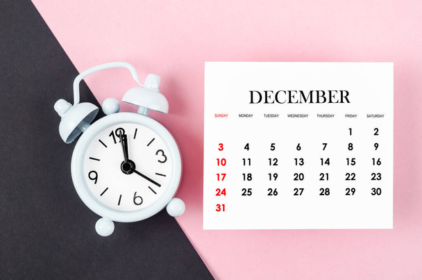 December 2023 Monthly calendar year with alarm clock on pink and black background. - Foto, imagen